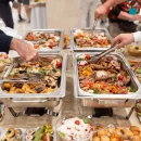 hands picking food buffet catering